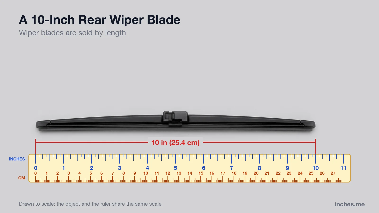 Black rear windshield wiper blade above a ruler, 10 inches long